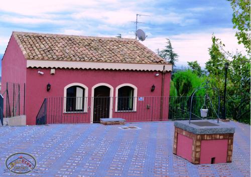 ein rotes Haus mit einem roten Zaun und einem Hof in der Unterkunft Agriturismo Dolcetna in SantʼAlfio