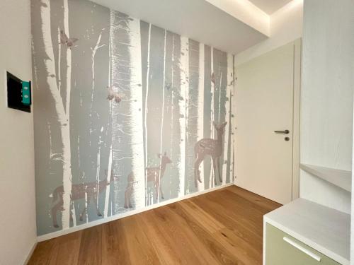 a room with a wall mural of trees and giraffes at Due Lune Home in Malcesine