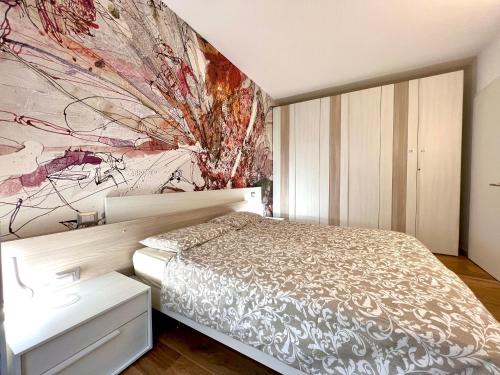 a bedroom with a bed and a painting on the wall at Due Lune Home in Malcesine
