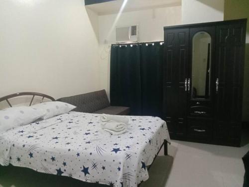 um quarto com uma cama e um armário preto em Unit Near SM City,Gaisano Mall of Cebu,Robinsons Galleria em Cebu