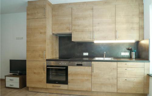 eine Küche mit Holzschränken, einer Spüle und einem Herd in der Unterkunft 1 Bedroom Stunning Apartment In Lngenfeld in Längenfeld