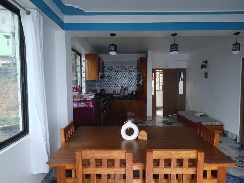 DENZONG HOMESTAY Lhadinkyu في Temi: غرفة طعام مع طاولة وكراسي خشبية