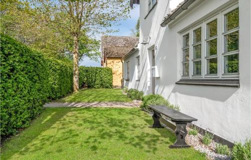 a bench sitting in the grass next to a house at Cozy Home In Rudkøbing With Wifi in Rudkøbing