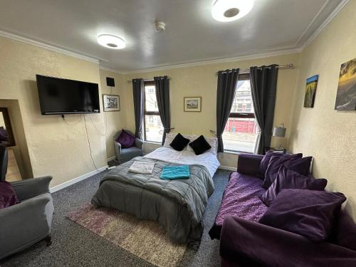 a bedroom with a bed and a couch at Belfast Duplex Apartment Siren Stays in Belfast