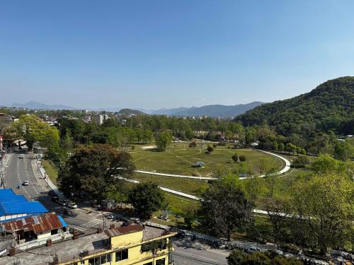 a view of a city with a road and a field at Hotel Lake Shore in Pokhara