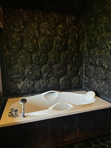 a sink in a bathroom with a stone wall at Bantunglom Resort in Mae Rim