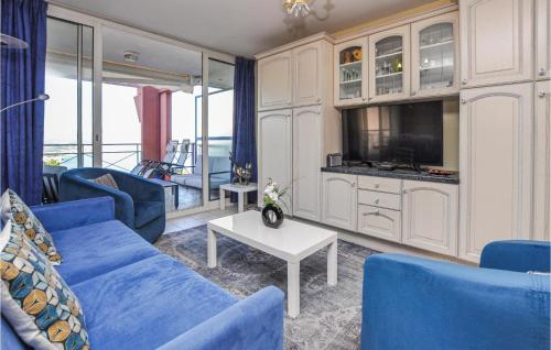 un salon avec des canapés bleus et une télévision dans l'établissement Gorgeous Apartment In Théoule-Sur-Mer, à Théoule-sur-Mer