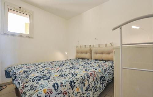 1 dormitorio con 1 cama con colcha de flores en Stunning Apartment In Thoule-sur-mer With Kitchen, en Théoule-sur-Mer
