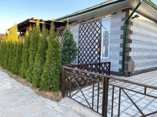 a house with a wooden railing next to a fence at Коттедж Чок-Тал Цо Париж 2 in Chok-Tal