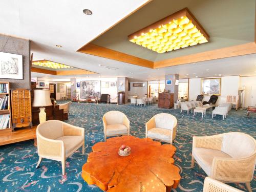 a lobby with chairs and a table in a room at Kumanoyu Hotel in Yamanouchi