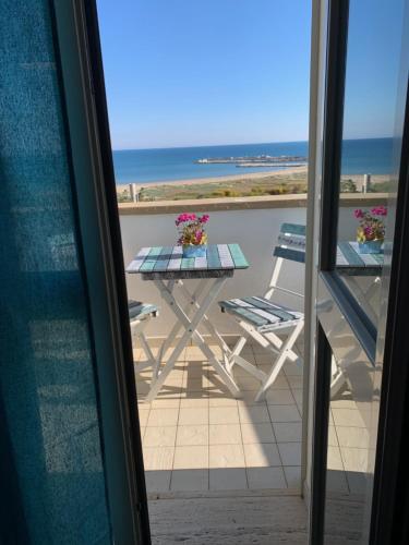 a table and chairs on a balcony with the ocean at La Bussola in Porto Palo