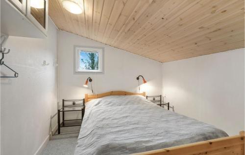 a bedroom with a large bed with a wooden ceiling at Cozy Home In Nex With Wifi in Neksø