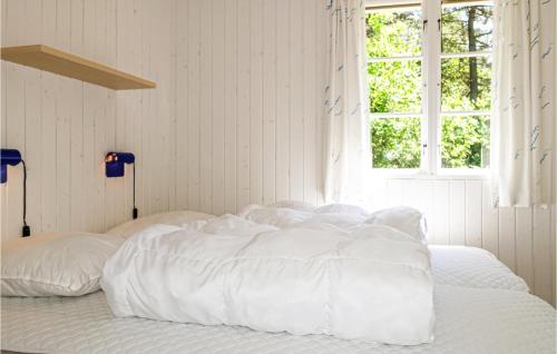 a white bed with white sheets and a window at Stunning Home In Aakirkeby With 3 Bedrooms And Wifi in Vester Sømarken