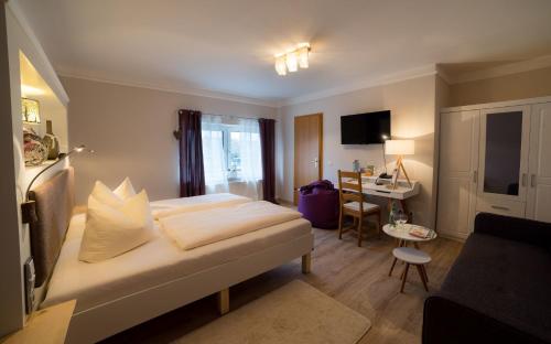 ein Hotelzimmer mit einem Bett und einem Schreibtisch in der Unterkunft Landhotel Rosenschänke in Kreischa