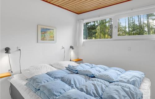 uma cama grande num quarto branco com uma janela em Lovely Home In Aakirkeby With Wifi em Vester Sømarken