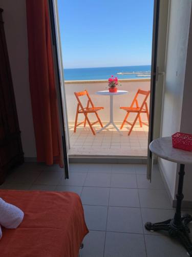 a room with a table and chairs on the beach at La Bussola in Porto Palo