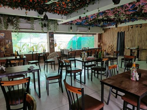 グルガオンにあるNearmi Hotels Banquets Medanta IKEA Sector 47 - Gurugramのテーブルと椅子、大きな窓のあるレストラン