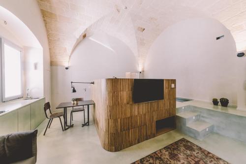 sala de estar con TV y mesa en Cinquevite, en Polignano a Mare