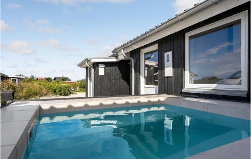 a swimming pool in front of a house at Cozy Home In Vestervig With Wifi in Vestervig