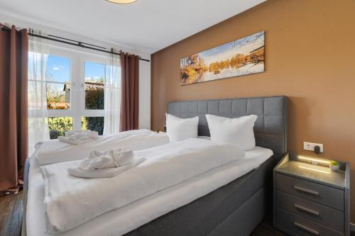 1 dormitorio con 1 cama blanca grande y ventana en Apartments Münchbach - near Europa-Park and Rulantica - Terrace I Parking I Kitchen I WiFi en Rust
