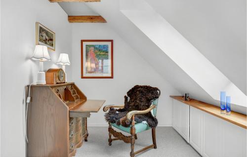 a dog sitting in a chair next to a desk at Awesome Home In Broager With House Sea View in Broager