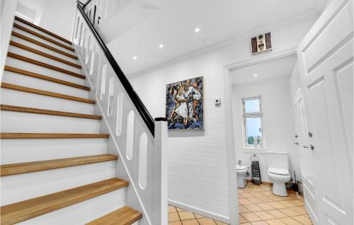 a white hallway with a staircase and a toilet at Awesome Home In Broager With House Sea View in Broager