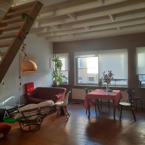 a living room with a red table and chairs at Atelier Aan Zee in Ostend