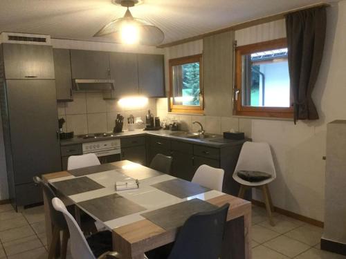 eine Küche mit einem Tisch und Stühlen in der Unterkunft Magnifique appartement de montagne in Leukerbad