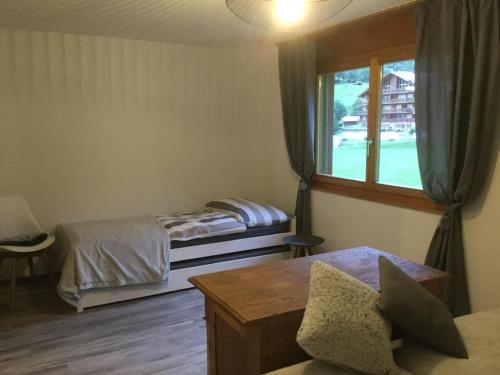 - une chambre avec 2 lits et une fenêtre dans l'établissement Magnifique appartement de montagne, à Loèche-les-Bains