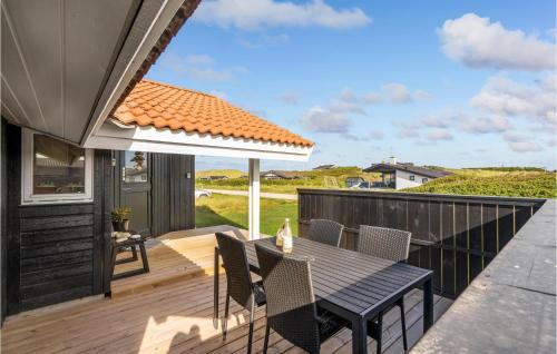 a patio with a table and chairs on a deck at 3 Bedroom Stunning Home In Thisted in Torsted