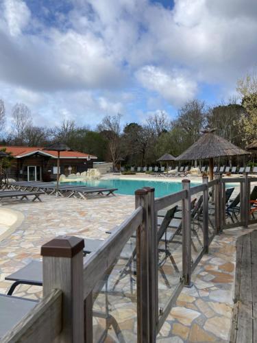 basen w ośrodku ze stołami i krzesłami w obiekcie Camping 5* - Biscarosse Lac - MobilHome 2 chambres - 4 personnes w mieście Biscarrosse