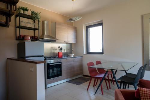 a small kitchen with a table and a dining room at Casa Terra d'Aci in Aci Bonaccorsi