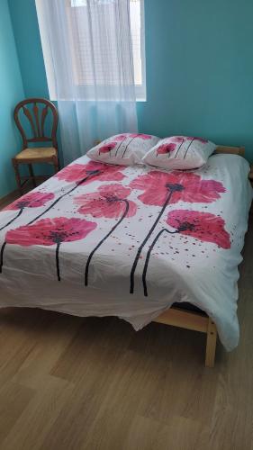 - une chambre dotée d'un lit avec une couverture rouge et blanche dans l'établissement Les Hauts de Sochaux, à Sochaux