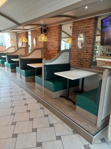 une salle à manger avec des tables et des chaises vertes dans l'établissement Hotel De La Mer, à Saint-Malo