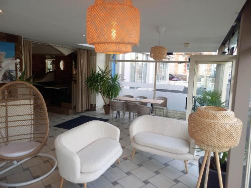 a living room with chairs and a table and a dining room at Hotel De La Mer in Saint Malo