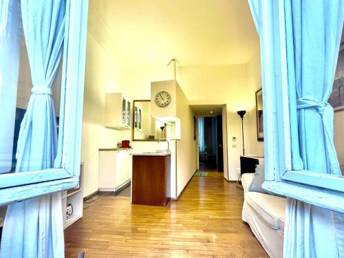 a room with blue curtains and a hallway with a clock at Sant’Onofrio - Trastevere Vatican apartment Roma in Rome