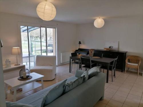 - un salon avec un canapé et un piano dans l'établissement Maison chaleureuse proche plage du Gurp, à Grayan-et-lʼHôpital