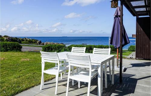 グドイェムにあるBeautiful Apartment In Gudhjem With House Sea Viewの白いテーブル(白い椅子、傘付)