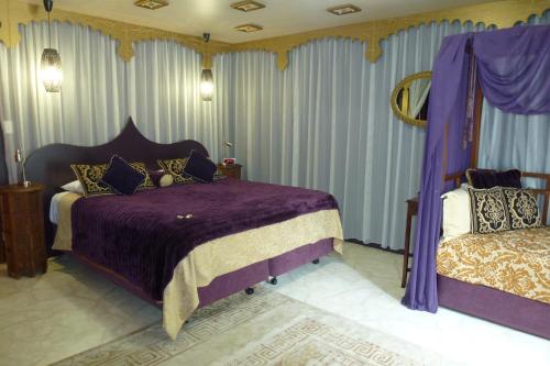 塔姆沃思的住宿－弗戈摩爾莊園酒店，一间卧室配有一张带紫色床单和窗帘的床