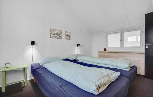 a bedroom with a large bed with blue sheets at Krebsen 649 in Ebeltoft