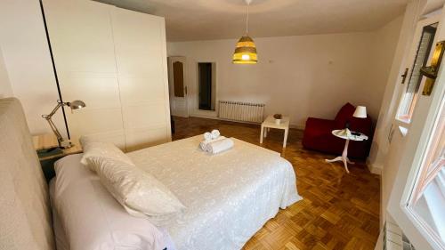 ein Schlafzimmer mit einem weißen Bett und ein Wohnzimmer in der Unterkunft Apartamento Hórreo -San Pelayo- in Cangas de Onís