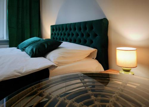 a bedroom with a bed and a table with a lamp at Hugo Eden Apartments in Kraków