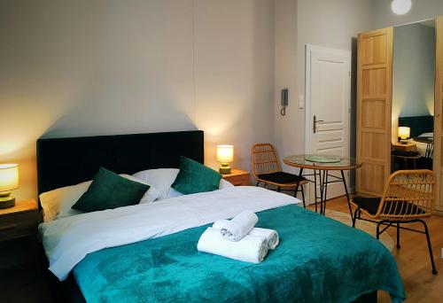 een slaapkamer met een bed met twee handdoeken erop bij Hugo Eden Apartments in Krakau