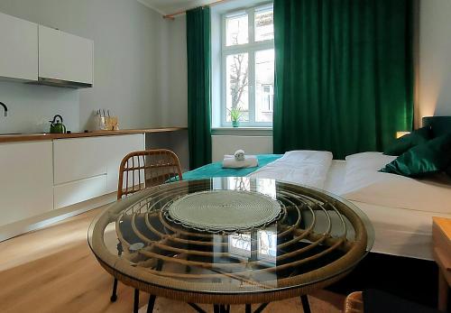 a living room with a table and a bed at Hugo Eden Apartments in Kraków
