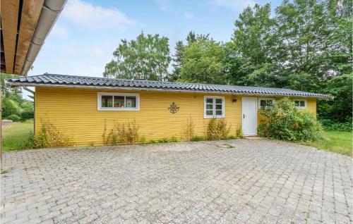 a yellow house with a driveway in front of it at Beautiful Home In Melby With Kitchen in Melby