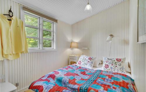 a bedroom with a bed with a colorful quilt at Beautiful Home In Melby With Kitchen in Melby