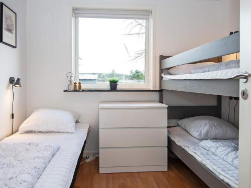1 Schlafzimmer mit 2 Etagenbetten und einem Fenster in der Unterkunft Holiday home Ebeltoft CXCVI in Ebeltoft