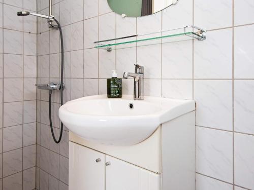 ein Badezimmer mit einem weißen Waschbecken und einer Dusche in der Unterkunft Holiday home Ebeltoft CXCVI in Ebeltoft
