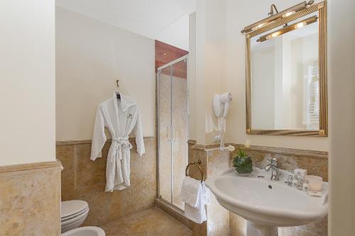 a bathroom with a sink and a toilet and a mirror at Dimora Degli Dei in Rome