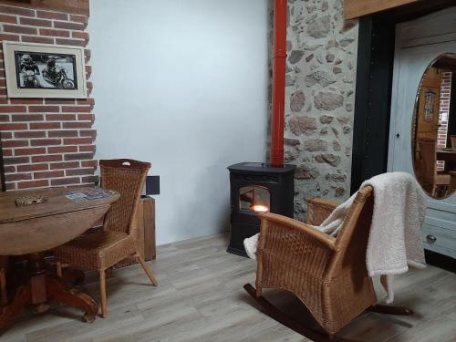 - un salon avec un poêle à bois et des chaises dans l'établissement Mont2roux, à Montpeyroux